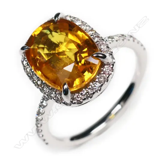 A 14ct white gold, yellow sapphire and diamond halo ring,