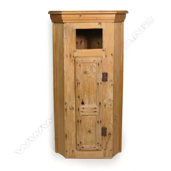 An early 19thC primitive pine hanging corner cabinet,