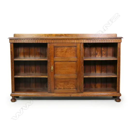 An early 20thC oak carved bookcase,