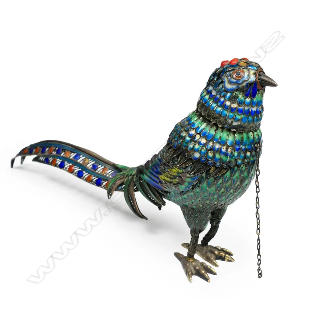 A silver gilt and enamel bird ornament with removeable head revealing the hollow body. Some  cabochons absent and minor enamel losses. Marked 'Silver' to the feet. L.180mm Image 1++