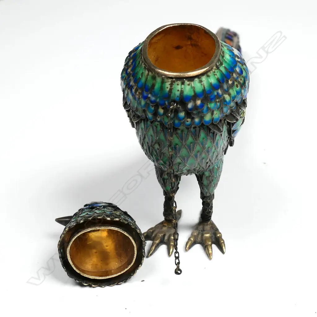 A silver gilt and enamel bird ornament with removeable head revealing the hollow body. Some  cabochons absent and minor enamel losses. Marked 'Silver' to the feet. L.180mm Image 1++