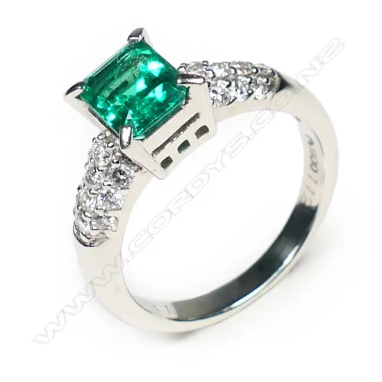 A platinum, emerald and diamond ring,