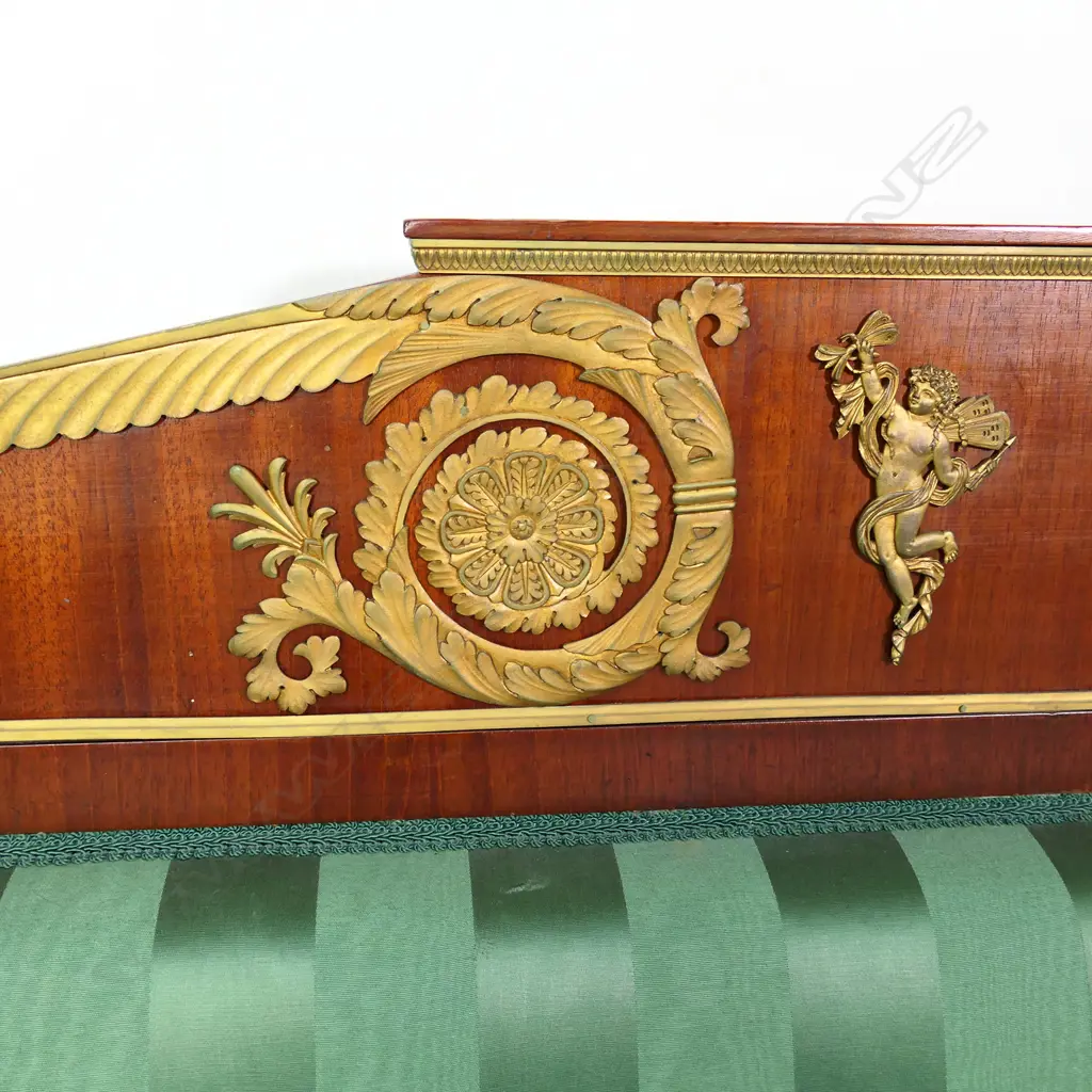 A 19thC French Empire style mahogany sofa, the architectural shaped back, sleigh frame and apron embellished with ormolu palmettes, rosettes, acanthus scrolls and figures, upholstered in a green Empire stripe fabric. Some veneer losses. 2250 x 720 x 1100mm Image 1++