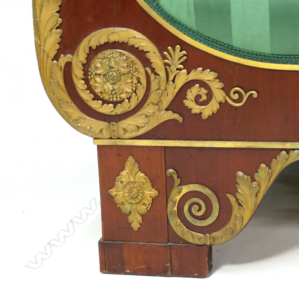 A 19thC French Empire style mahogany sofa, the architectural shaped back, sleigh frame and apron embellished with ormolu palmettes, rosettes, acanthus scrolls and figures, upholstered in a green Empire stripe fabric. Some veneer losses. 2250 x 720 x 1100mm Image 1++