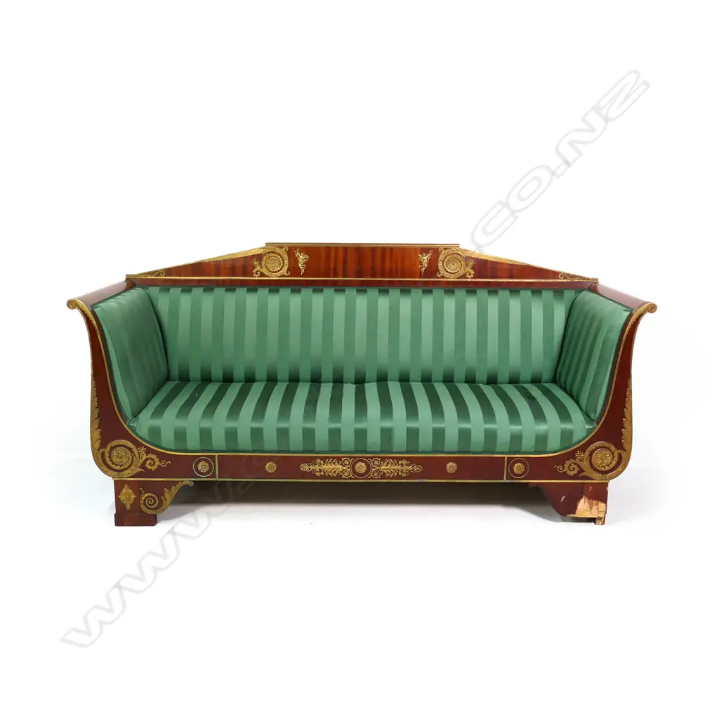 A 19thC French Empire style mahogany sofa, the architectural shaped back, sleigh frame and apron embellished with ormolu palmettes, rosettes, acanthus scrolls and figures, upholstered in a green Empire stripe fabric. Some veneer losses. 2250 x 720 x 1100mm Image 1++