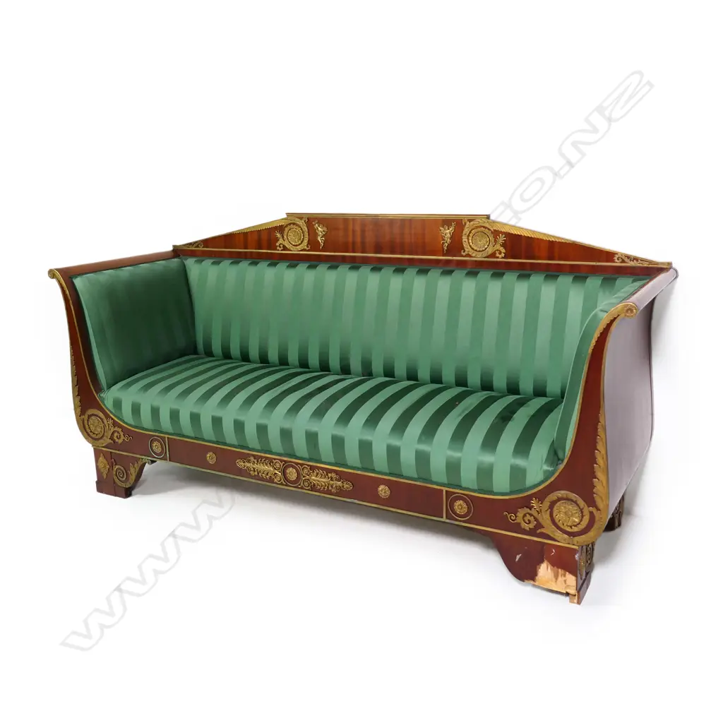 A 19thC French Empire style mahogany sofa, the architectural shaped back, sleigh frame and apron embellished with ormolu palmettes, rosettes, acanthus scrolls and figures, upholstered in a green Empire stripe fabric. Some veneer losses. 2250 x 720 x 1100mm Image 1++