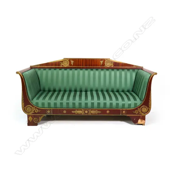 A 19thC French Empire style mahogany sofa, the architectural shaped back, sleigh frame and apron embellished with ormolu palmettes, rosettes, acanthus scrolls and figures, upholstered in a green Empire stripe fabric. Some veneer losses. 2250 x 720 x 1100mm