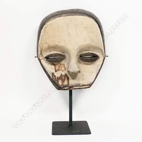 An African Congo carved wood mask,  with white pigment painted face,
