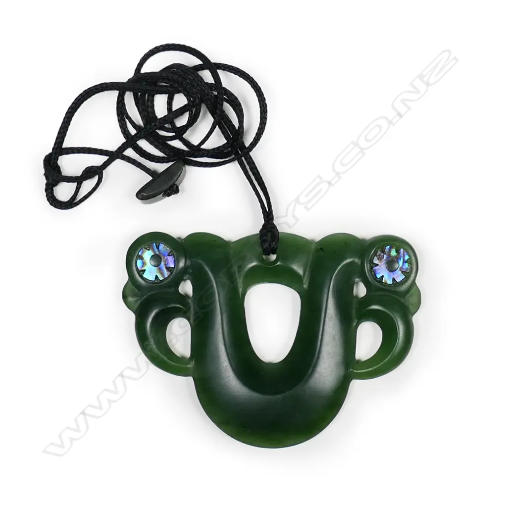 A contemporary pounamu pekapeka, double sided, with serrated paua inlaid ring eyes. Image 1++
