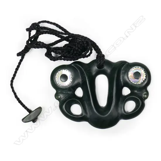 A contemporary pounamu pekapeka, with serrated paua inlaid ring eyes.