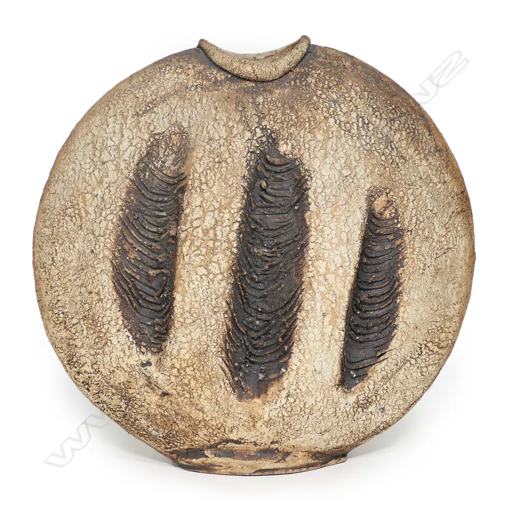 A Len Castle discoid stoneware vase, three heavily combed vertical rope impressions to each side, concave mouth, iron oxide washed matt glaze, impressed potter’s mark. H.355mm Image 1++