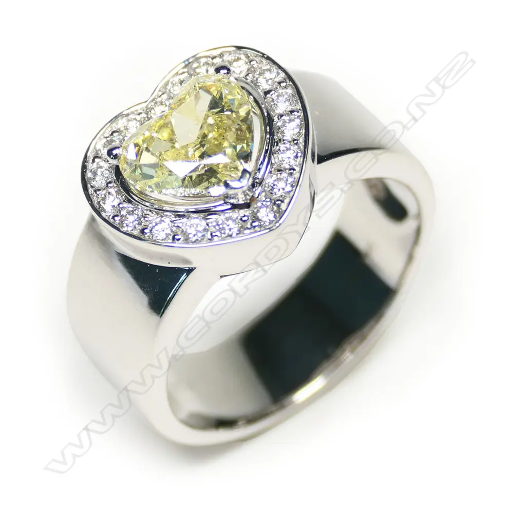 An 18ct white gold, fancy yellow diamond heart halo ring, Image 1++