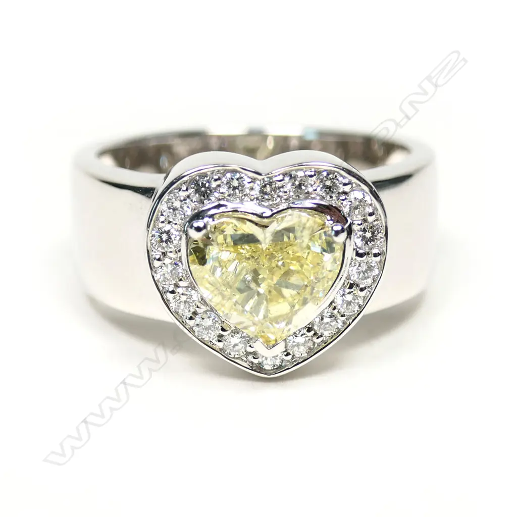 An 18ct white gold, fancy yellow diamond heart halo ring, Image 1++