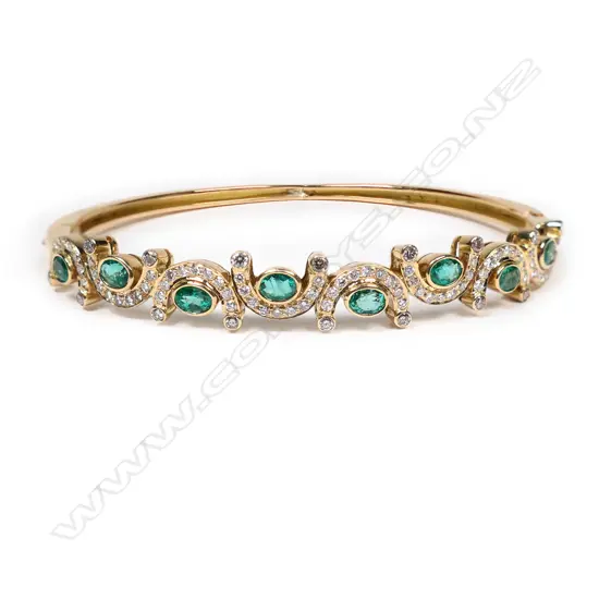 An 18ct gold, diamond and emerald hinged bangle,