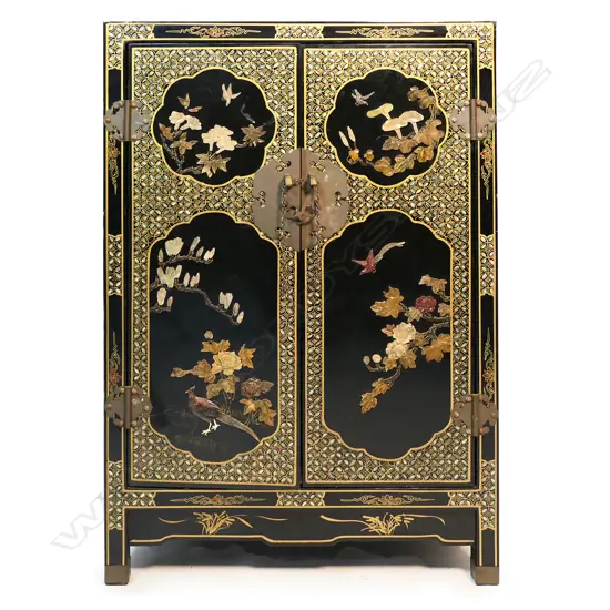 A vintage oriental black lacquer small cupboard with carved coloured stone decoration,