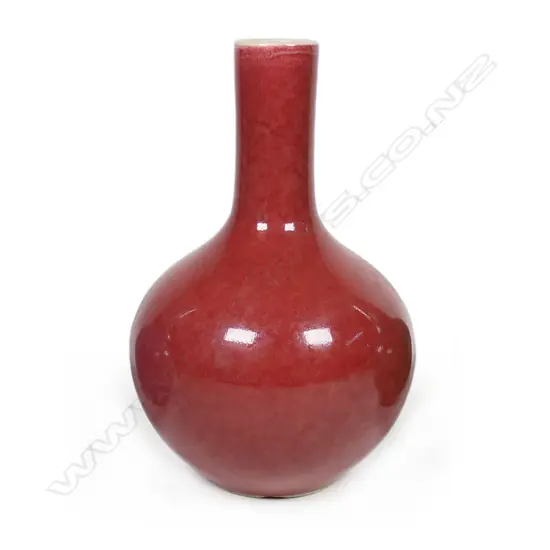 A Chinese monochrome peach bloom, copper red glazed bottle vase, baluster shape. Qianlong/Jiaqing period.