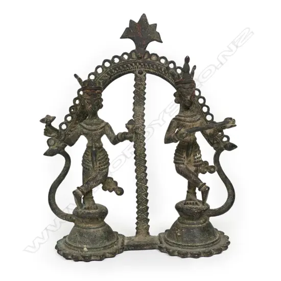 An Indian bronze statuette, of two figures holding objects stand in mirrored pose,