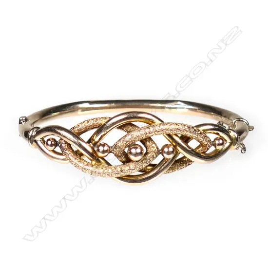 An Edwardian 9ct rose gold, elaborate knot hinged bangle,