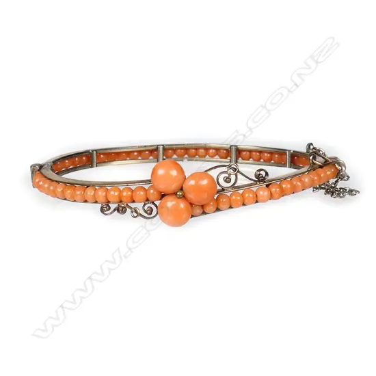 A vintage gold plated and coral hinged bangle,