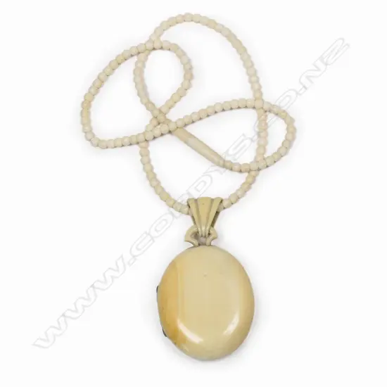 A vintage ivory mourning locket on ivory chain,