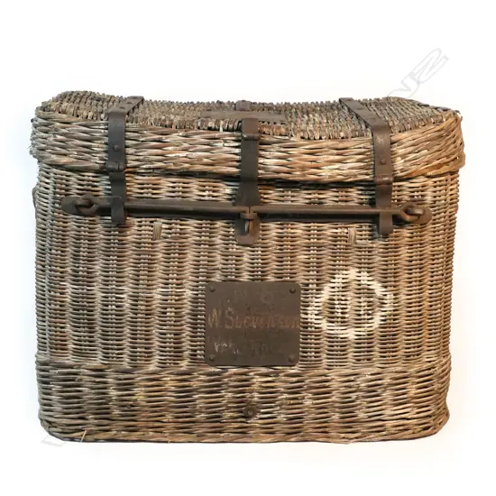 A large and characterful woven cane and metal bound travelling trunk,