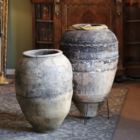 Two antique oil jars (repaired) one on stand H.860 and 690mm