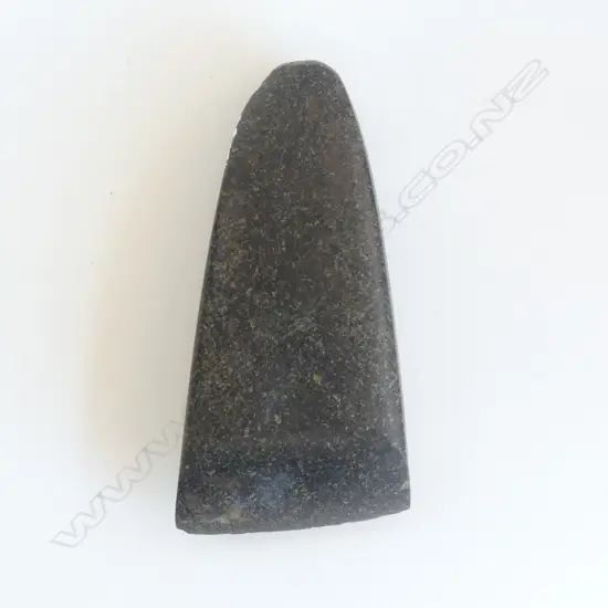 An old Māori toki of dark tone with fine fleck,