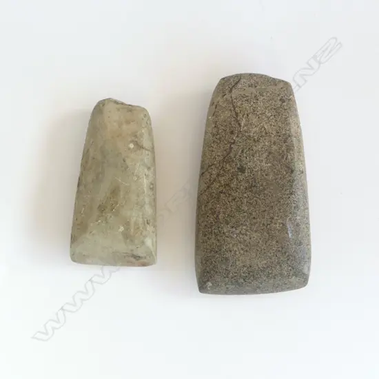 Two old Māori stone toki the larger of speckled grey stone,