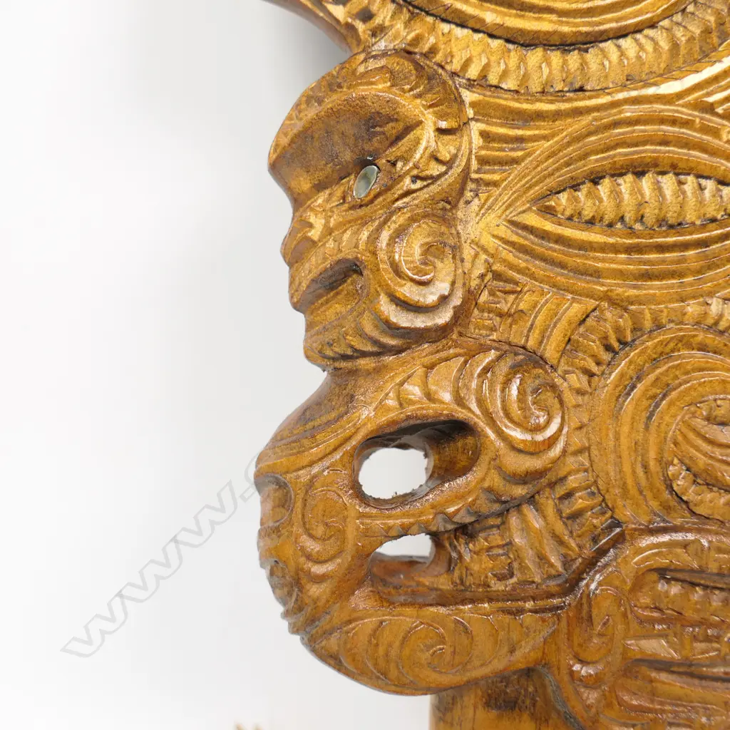 A Māori carved wahaika, double and triple scroll carved blade, full figure to one edge, weku carved butt. c.1980. Image 1++