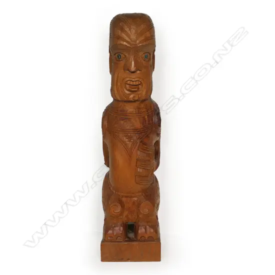 A Māori carved poutokomanawa with one hand to the front,
