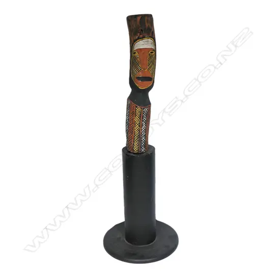 An Aboriginal painted wood carving on a plinth,