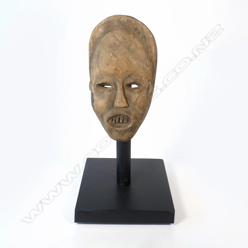 A Congolese light wooden face mask on stand, Image 1++