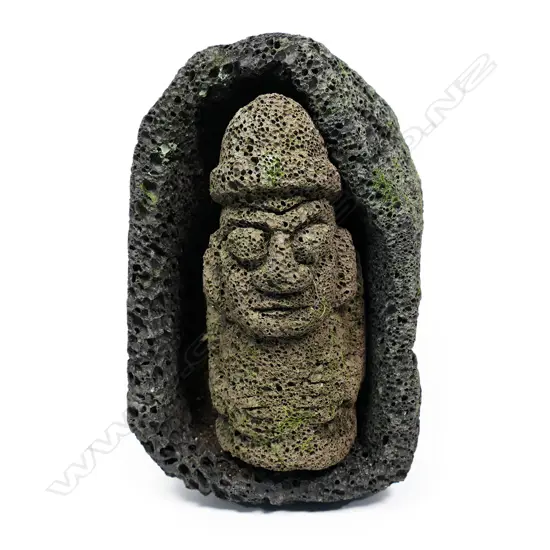 A Korean 'Dol Hareubang' carved god statue in a 'cave' form surround,