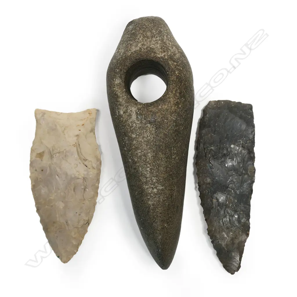 A good stone battle-axe hammer-head, probably Nordic Neolithic, pecked and polished finish, blunted tapering poll, cylindrical perforation, wedge shaped blade with small chips to edge. L.130mm. Along with a North American fluted paleo Clovis point, found Erie County, Ohio, L.95mm; and a Clovis (Alabama) Dalton point of cream/white chert, L.82mm. Provenance: The Jorgen Lotz Collection. Image 1++