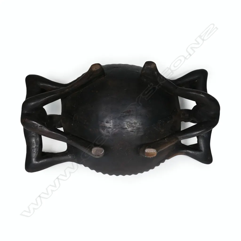 An Indonesian figure supported large wooden bowl with five small tribal figures Image 1++