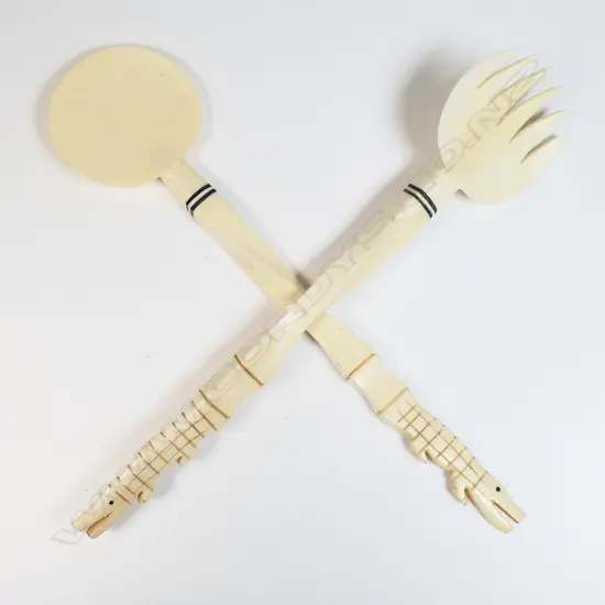 A pair of African carved ivory salad servers,