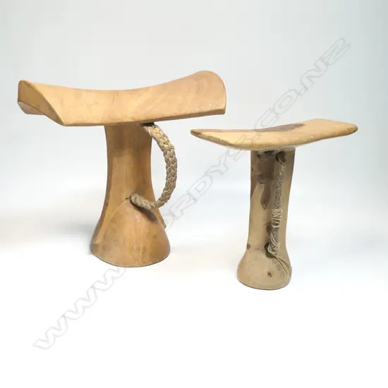 Two African carved wood headrests, bar form supports, pale wood. H's.205 & 165mm. Provenance: Ex. The Estate of John Perry.