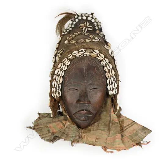 African female Dan mask carved wood with fabric backed head cover highlighted with shells. H.400mm. Provenance: Ex. The Estate of John Perry.