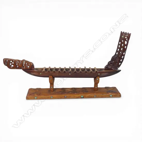 A large mid / late 20thC Māori carved wood model waka on carved stand,