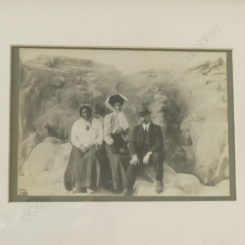 A vintage photograph of a Māori guide with a framed reprint 'Fryingpan Flat and Waimangu - Ten Days After Eruption' by C. Spencer, Image 1++