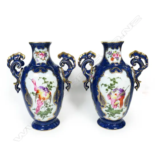 A pair of 18thC style mantel vases, painted in polychrome enamels with panels reserved on a scale blue ground and exotic birds and floral sprays,