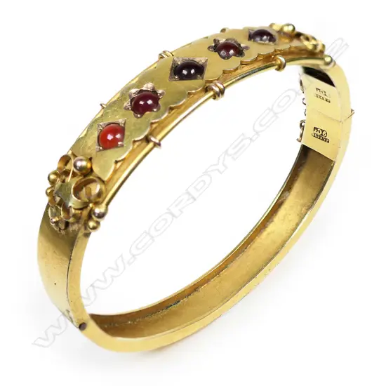 A late 19thC 9ct yellow gold and garnet hinged bangle,