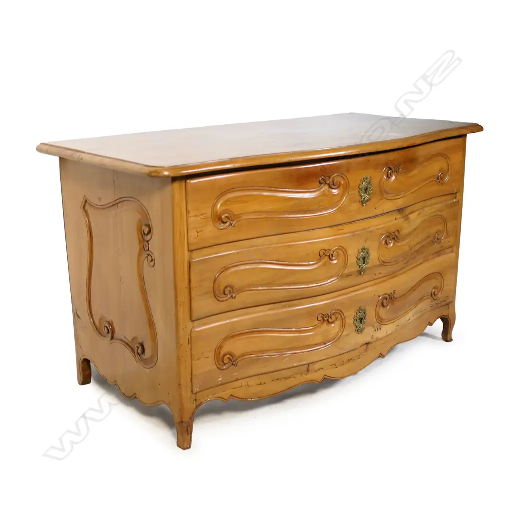 A continental fruitwood chest of drawers. Serpentine shape - three full width drawers with carved detail. Raised on slight cabriole legs (one foot requires attention). 1360 x 680 x 790mm. Image 1++