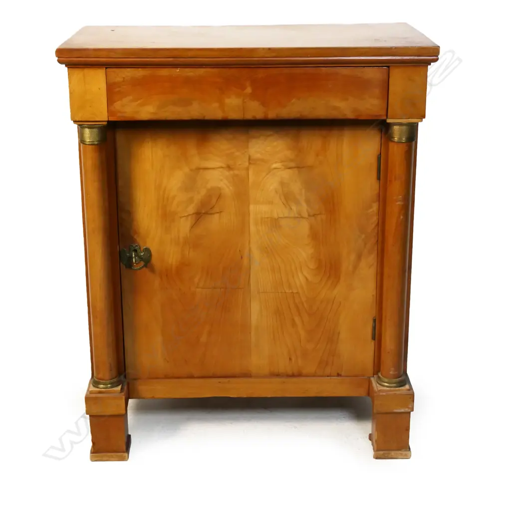A birch Biedermeier cabinet: frieze drawer over one door and column to each side with brass detail. Raised on square section feet -  one absent. 730 x 390 x 910mm. Image 1++