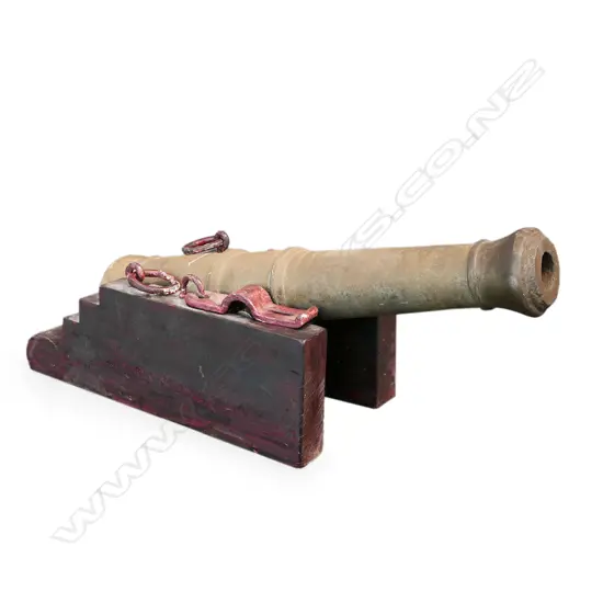 A iron cannon in wooden stand,