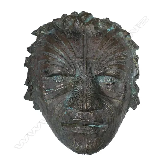 A contemporary bronze sculpture of a male Māori face,