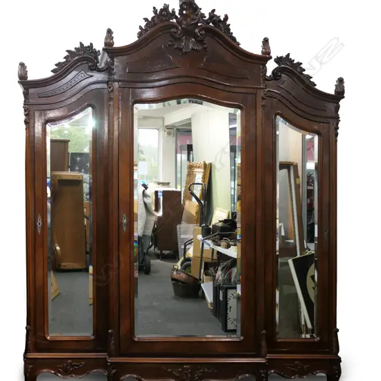 A large French antique style walnut three door breakfront armoire,