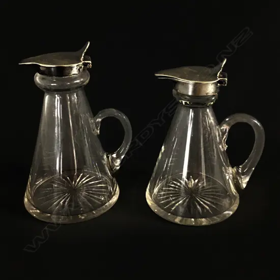 Two silver topped glass noggin jugs,