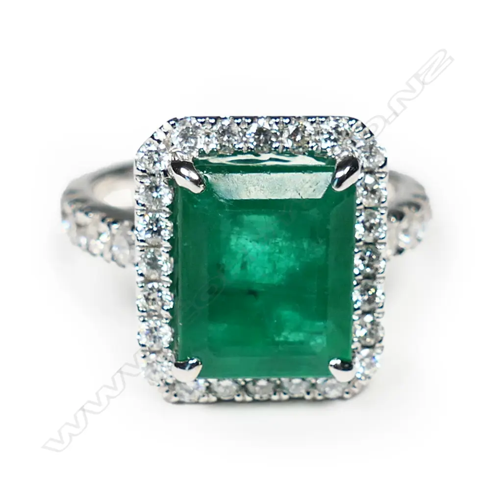 @ An 18ct white gold emerald and diamond cluster ring Image 1++