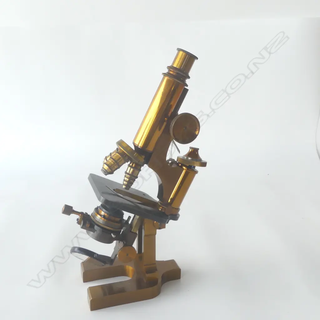 An Ed. Messter of Berlin lacquered brass compound microscope, rectangular horseshoe base, slotted pillar, tubular limb with triangular rod, topped by fine adjuster. Substage lens, iris diaphragm and double mirror. Body tube with double milled head pinion, triple objective lens swivel cluster. Signed and dated 1894 under the base. Provenance: ex The Jack Thornton estate collection. Image 1++